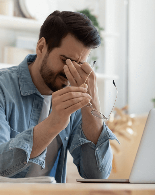 Mann mit Konzentrationsschwierigkeiten am Laptop wegen ME/CFS.