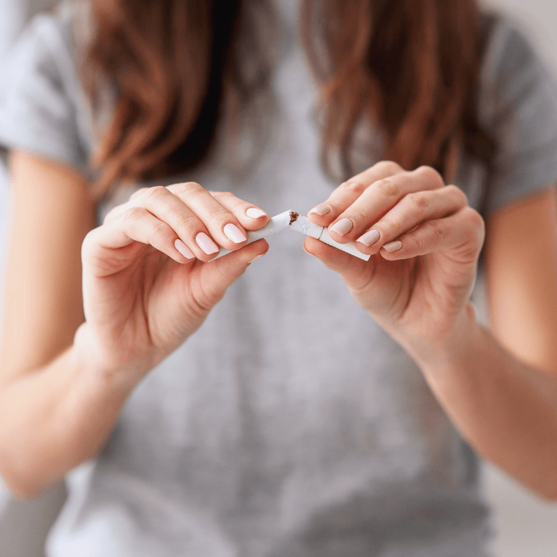 Frau zerbricht Zigarette in ihrer Hand und startet mit der Raucherentwöhnung in der Privatpraxis Kosttor.