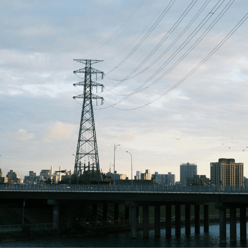 Strommast vor einer Großstadt.