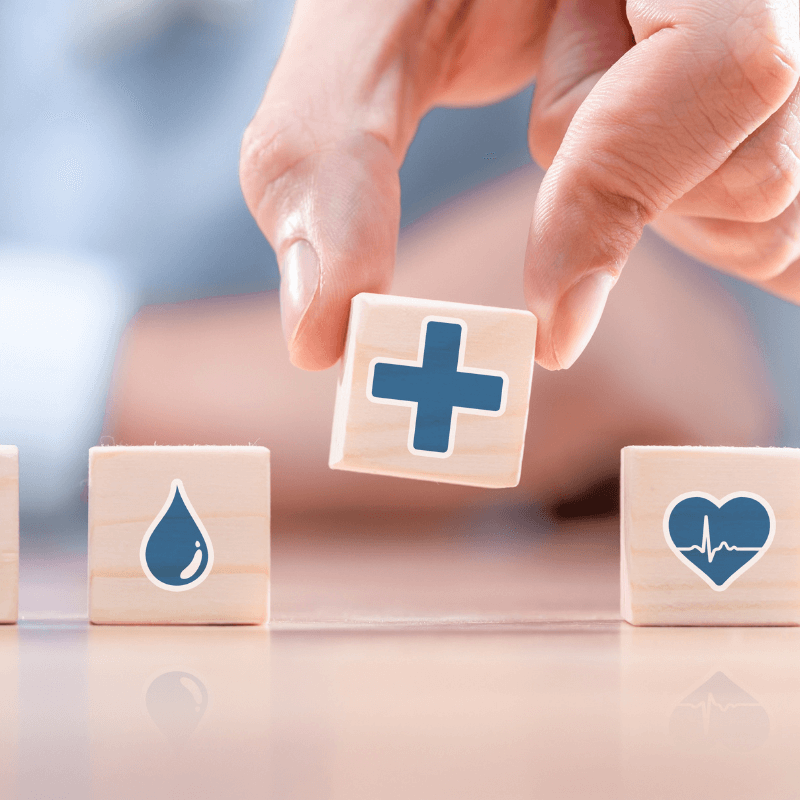 Holz-Bausteine symbolisieren die Bestandteile der Gesundheitsvorsorge in der Privatpraxis Kosttor in München.